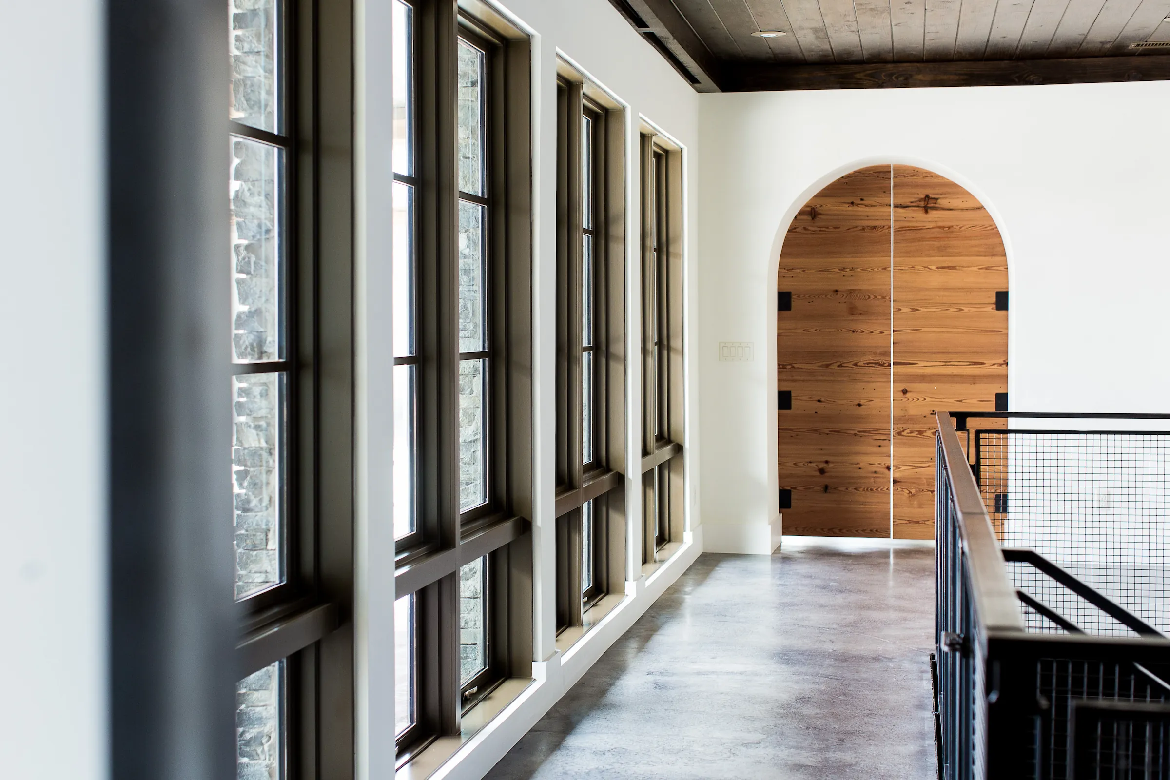 hallway with windows leading to a door